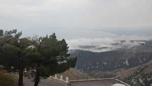 davanti al panorama della roccia che scende sino al mare